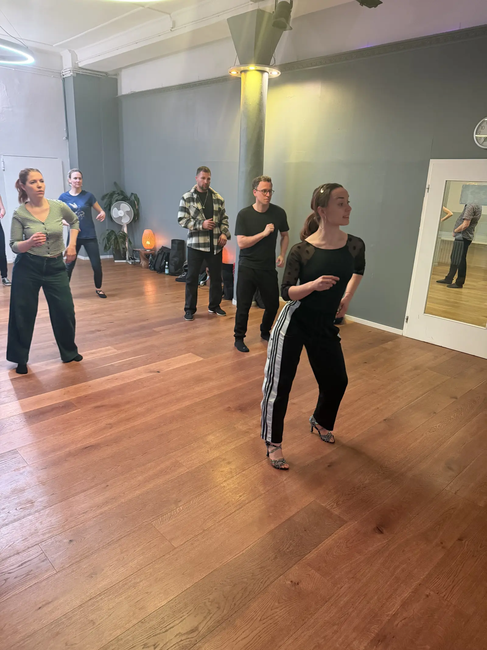 Students lined up in the studio practicing salsa footwork