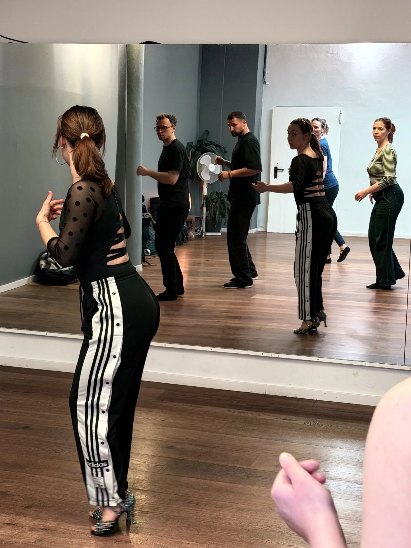 Lucy demonstrating styling at the mirror while students watch